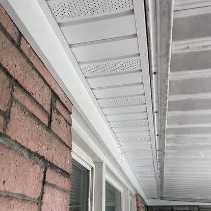 Close detail of new white vented soffit and fascia installed against pink brick in Red Lion, Pennsylvania