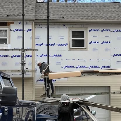 Crew on a scaffold installing new siding over Alside house wrap on a home in Dover, Pennsylvania