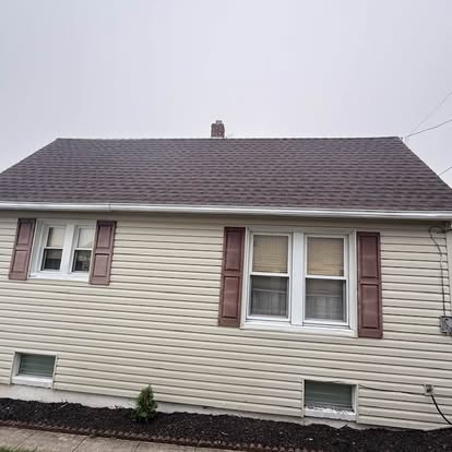 Completed brown architectural shingle roof on a cream-sided ranch home in Spring Grove, Pennsylvania