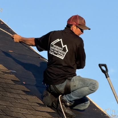 Thompson Home Improvements crew member in a branded company t-shirt working along a roof ridge in York County, Pennsylvania