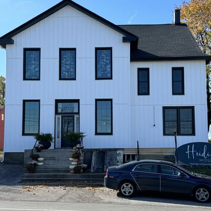 White board-and-batten two-story building with a newly installed dark shingle roof in Glen Rock, Pennsylvania
